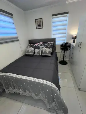 a bedroom with a black bed with pillows on it at The MK House in Cape Town