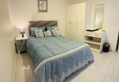 a bedroom with a large bed with blue sheets and pillows at The MK House in Cape Town