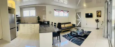 a kitchen and living room with a couch and a table at The MK House in Cape Town