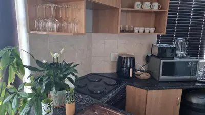 a kitchen with a stove and a microwave at Corner View in Paarl