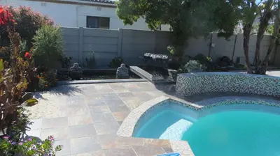 a swimming pool in a yard with a patio at Tucker's Self Catering Flatlet in Cape Town