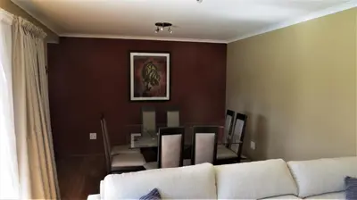 a living room with a couch and a dining room at Tucker's Self Catering Flatlet in Cape Town