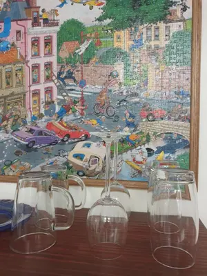 four wine glasses sitting on a table in front of a painting at Hibiscus B&B in Strand