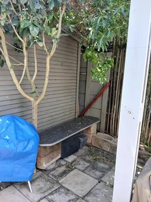 a bench next to a door with a tree at Rusticana Room1 in Cape Town