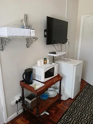 a microwave and a refrigerator in a room at Rusticana Room1 in Cape Town