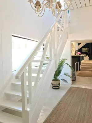 a white staircase in a living room with a potted plant at Best of Both! Mountain and Sea View Home. in Hermanus
