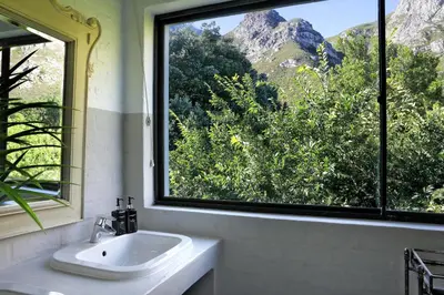 a bathroom with a sink and a large window at Best of Both! Mountain and Sea View Home. in Hermanus