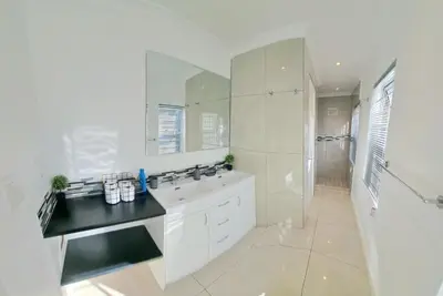 a white bathroom with a sink and a shower at Heart of Obz in Cape Town