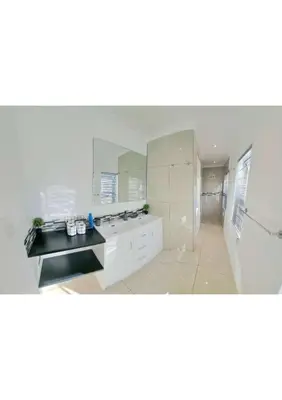 a white bathroom with a sink and a shower at Heart of Obz in Cape Town