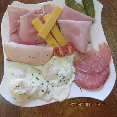 a plate of food with eggs cheese and other foods at Guesthouse De Tijger Lodge in Parow