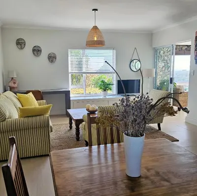a living room with a table with a vase on it at Casa La Vista in Somerset West