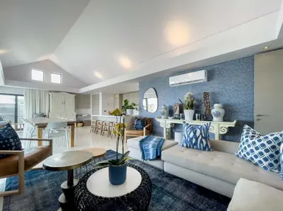 a living room with a couch and a table at Le Paradis Penthouse in Hermanus