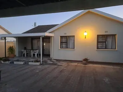 a house with a patio with a table and chairs at Addai Self Catering Brackenfell Durbanville area in Cape Town