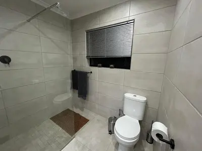 a white bathroom with a toilet and a shower at Addai Self Catering Brackenfell Durbanville area in Cape Town