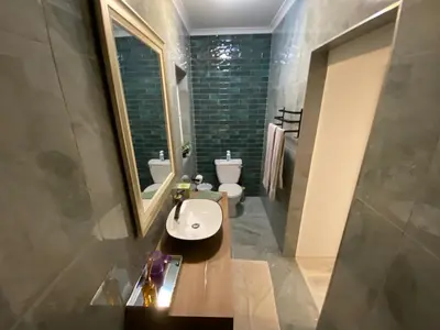 a bathroom with a sink and a toilet and a mirror at Marble Maison in Franschhoek