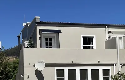 a white house with a satellite on the side of it at Marble Maison in Franschhoek