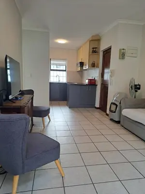 a kitchen and living room with a couch and a table at Casa Table View in Cape Town