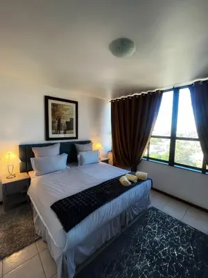 a bedroom with a large bed and large windows at Stay with me in Cape Town