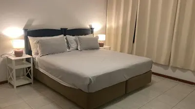 a bedroom with a large bed with white sheets and pillows at Stay with me in Cape Town