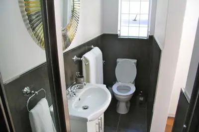 a small bathroom with a toilet and a sink at Lazy Days Apartments - Cape Town in Cape Town