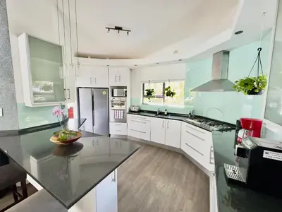 a kitchen with white cabinets and a black counter top at The Kite Villa - Luxury Kitesurfing Guesthouse in Cape Town