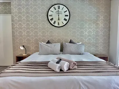 a bedroom with a large clock on a bed at The Kite Villa - Luxury Kitesurfing Guesthouse in Cape Town