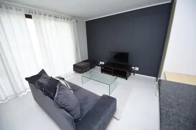 a living room with a couch and a television at The Island Club Apartment in Cape Town