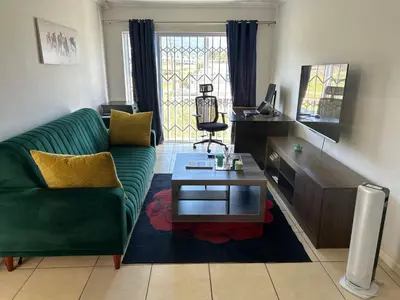 a living room with a green couch and a coffee table at 2 Bedroom Shared kitchenette Apartment with beautiful views in Stellenbosch