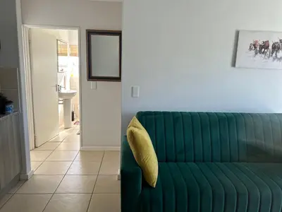 a green couch sitting in a living room at 2 Bedroom Shared kitchenette Apartment with beautiful views in Stellenbosch