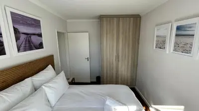 a bedroom with a bed and three pictures on the wall at 2 Bedroom Shared kitchenette Apartment with beautiful views in Stellenbosch