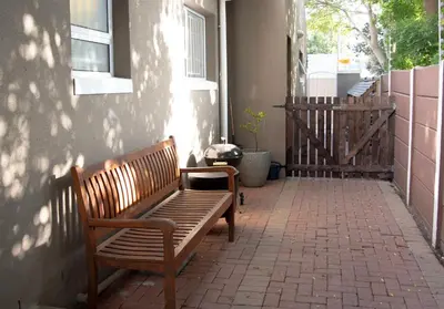 a bench sitting on the side of a building at Panthera Cottage Milnerton in Cape Town