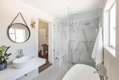 a white bathroom with a sink and a mirror at Silvertree Collective Central Family Home in Stellenbosch