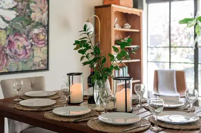 a dining room table with plates and candles on it at Silvertree Collective Central Family Home in Stellenbosch