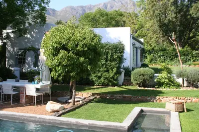 a backyard with a table and a tree at The Cottage on 55 in Franschhoek
