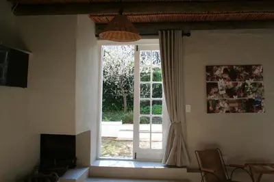 a living room with a door to a yard at The Cottage on 55 in Franschhoek