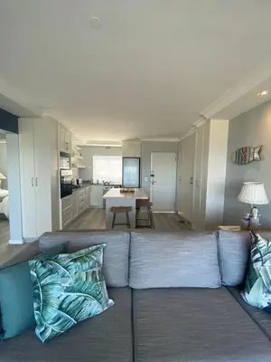 a living room with a couch and a kitchen at 42 Whale Rock Estate in Hermanus