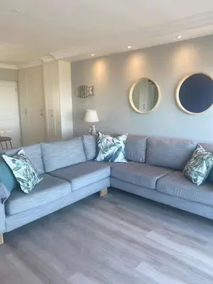 a blue couch in a living room with two mirrors at 42 Whale Rock Estate in Hermanus