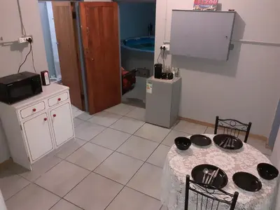 a kitchen with a table with chairs and a tv at MJ's Self Catering in Wolseley