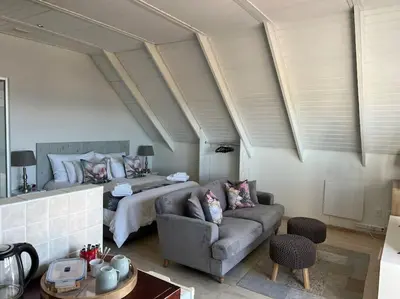 a living room with a couch and a bed at Tranquility Betty's Bay in Sunny Seas
