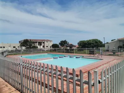 a large swimming pool with a fence around it at Hermanus Beach Club 143 in Hermanus