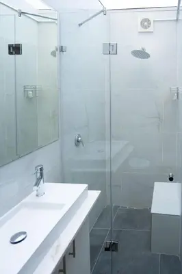 a bathroom with two sinks and a glass shower at The One on Pienaar in Cape Town