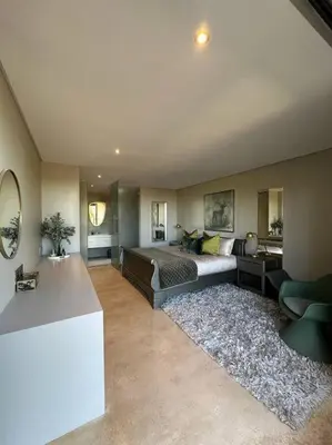 a bedroom with a bed and a living room at Luxury Vineyard Apartment in Cape Town