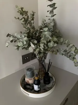 a vase with flowers and candles on a table at Luxury Vineyard Apartment in Cape Town