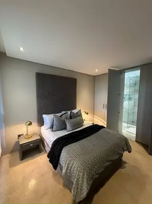 a bedroom with a large bed with pillows on it at Luxury Vineyard Apartment in Cape Town