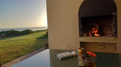 a fireplace in a house with a view of a field at Oceans Edge - Hermanus Beach Club in Hermanus