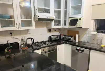 a kitchen with white cabinets and a stove top oven at Oceans Edge - Hermanus Beach Club in Hermanus