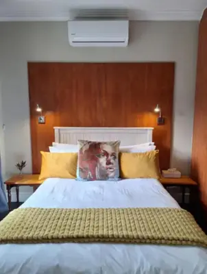 a bedroom with a large bed with yellow pillows at Apartment in central Stellenbosch in Stellenbosch