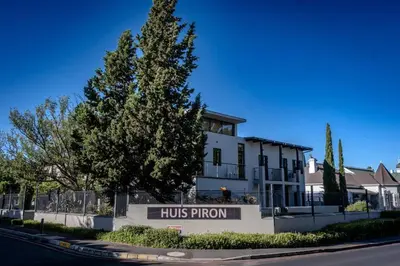 a white building with a hosrow sign in front of it at Apartment in central Stellenbosch in Stellenbosch