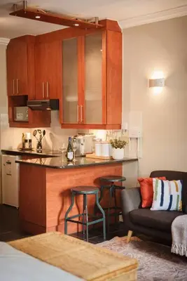 a kitchen with a bar and a couch in a room at Apartment in central Stellenbosch in Stellenbosch