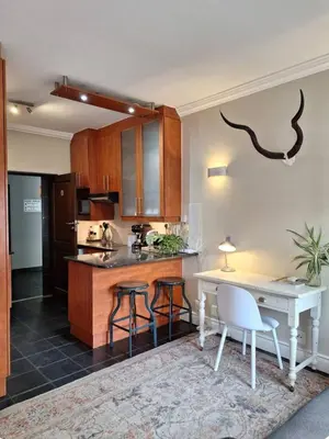 a kitchen with a counter and a table and chairs at Apartment in central Stellenbosch in Stellenbosch